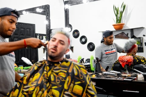 Barbers cutting hair of customers